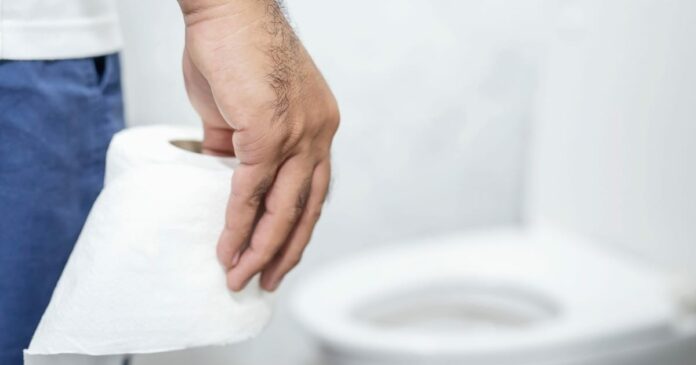 Hand holding roll of toilet paper
