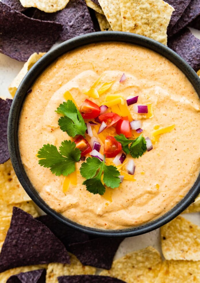 Cottage cheese queso in a small bowl with tortilla chips.