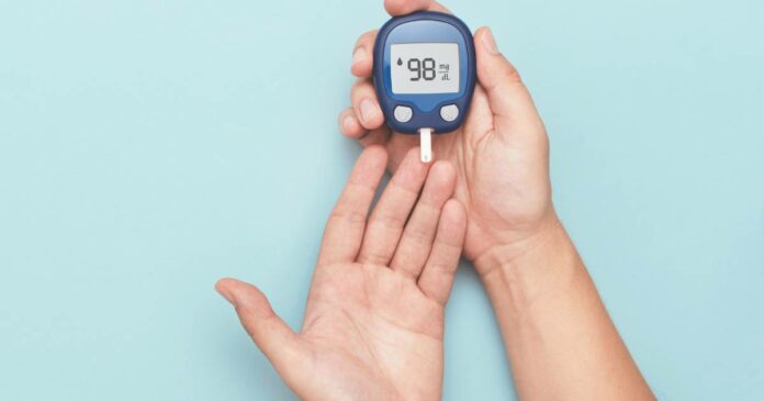 Close up of hands using a blood sugar monitor