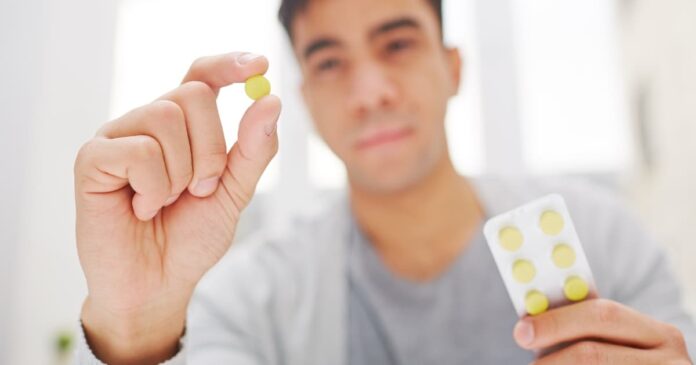 Man holding combination drug pill