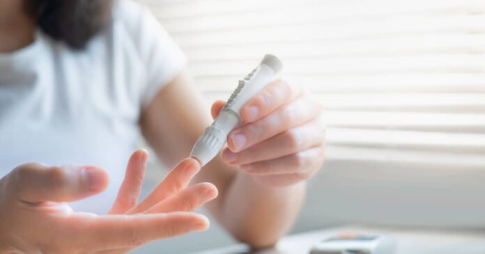 Woman measuring her blood sugar to test for reactive hypoglycemia