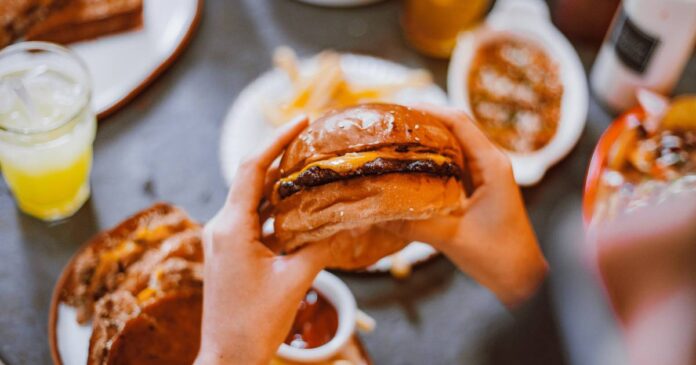 Hands holding a cheeseburger