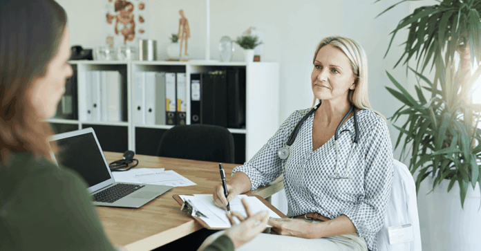 Female health professional in office talking to client